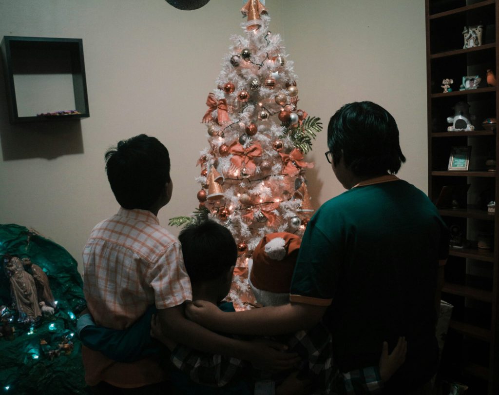backs of family looking at Christmas tree