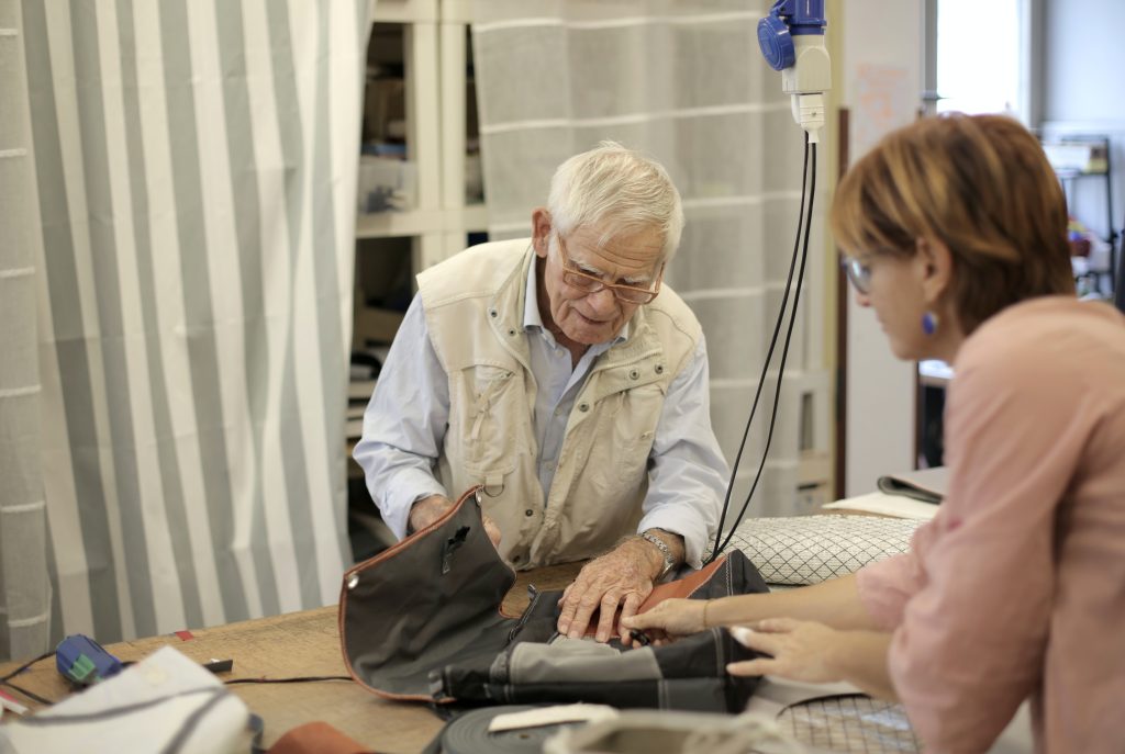 Older man working on project with assistance