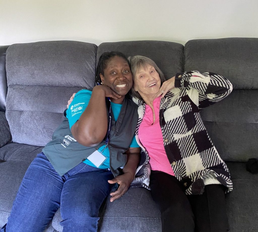 Senior Companion Marie poses with client on a couch